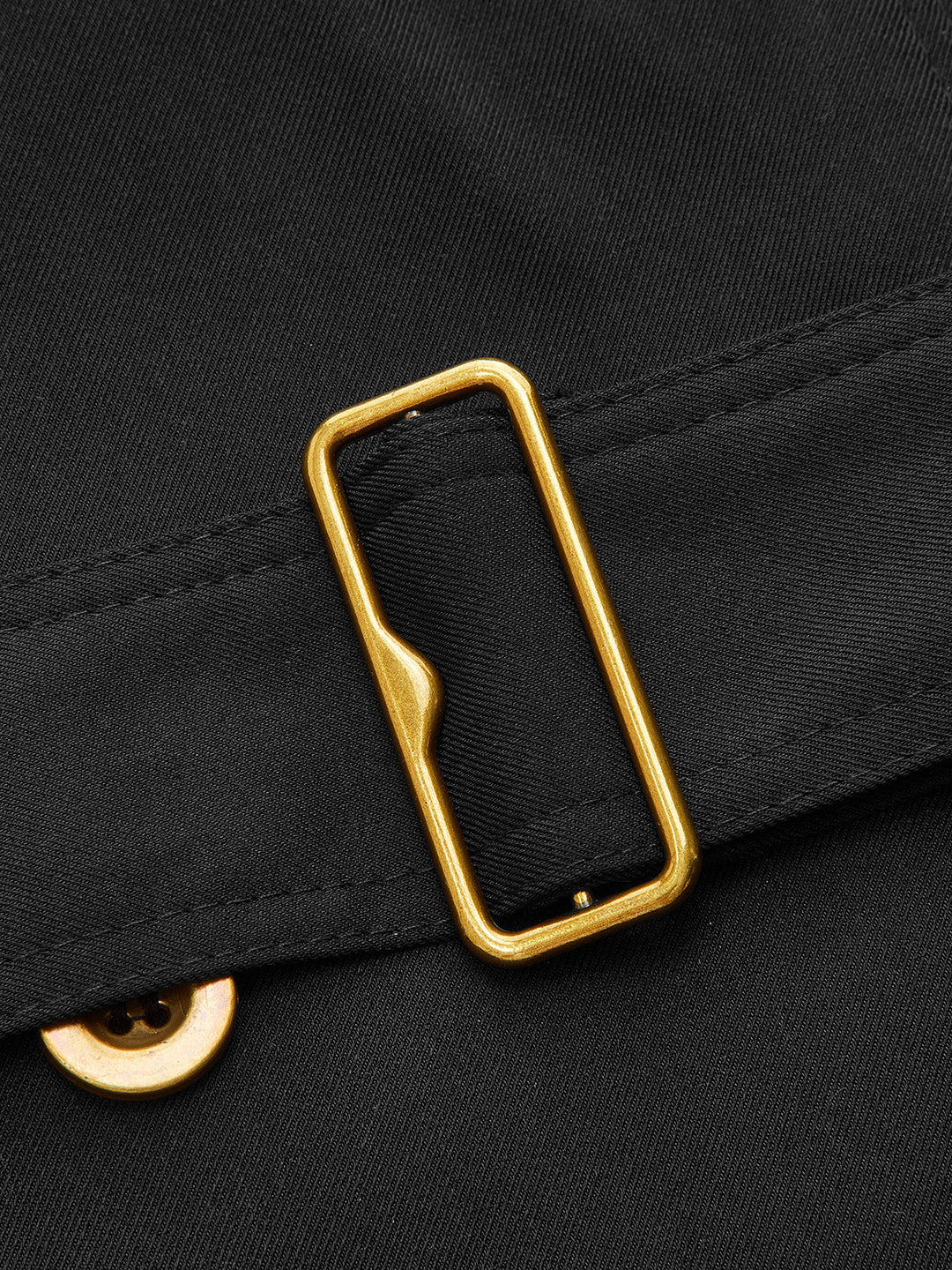 Close-up of the gold rectangular belt buckle on black twill