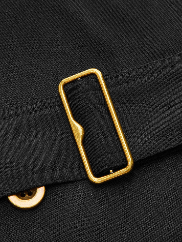 Close-up of the gold rectangular belt buckle on black twill
