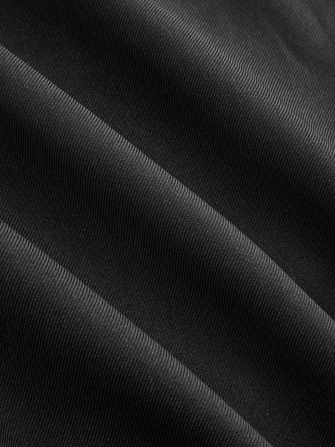 Fabric detail showing the matte black cotton twill of the military jacket