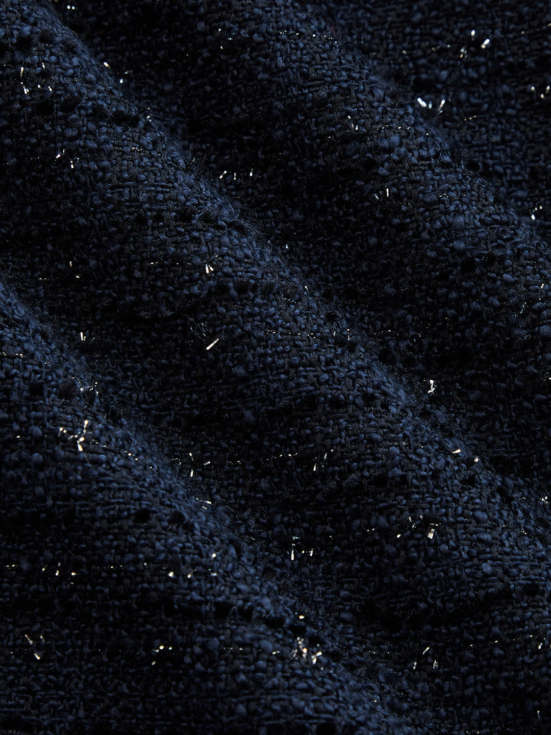 Fabric close-up of navy sparkle tweed with woven lurex flecks