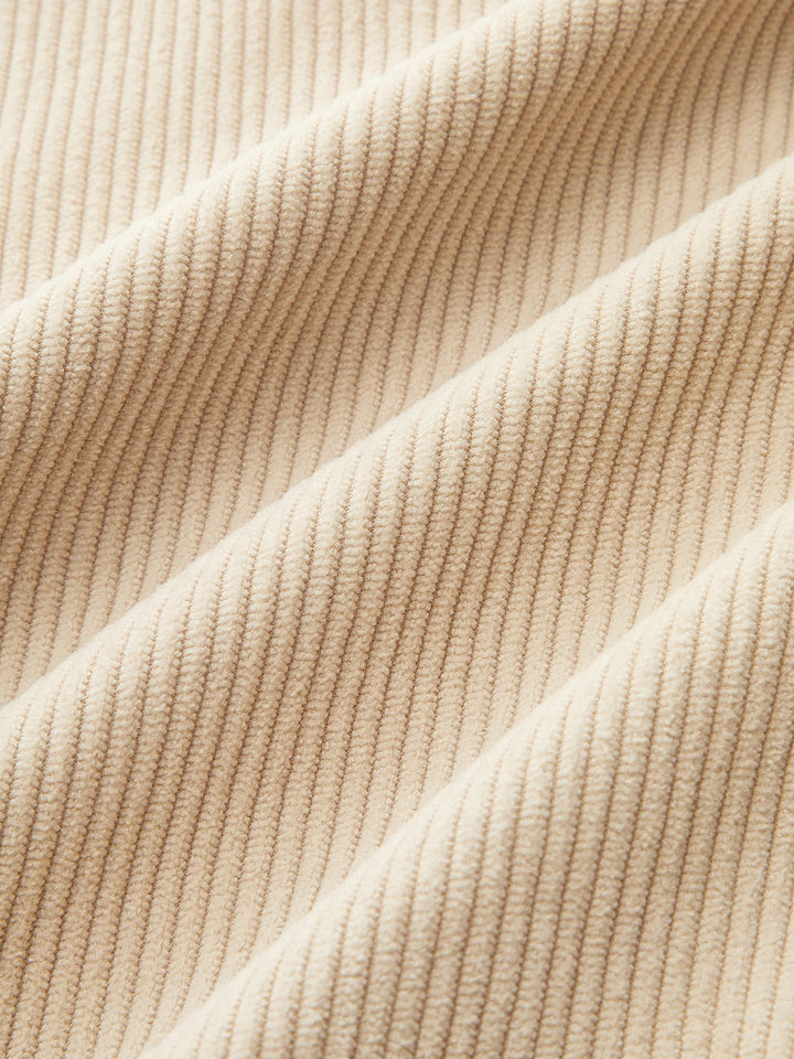 Close-up of fine beige corduroy fabric showing the soft vertical ribbing