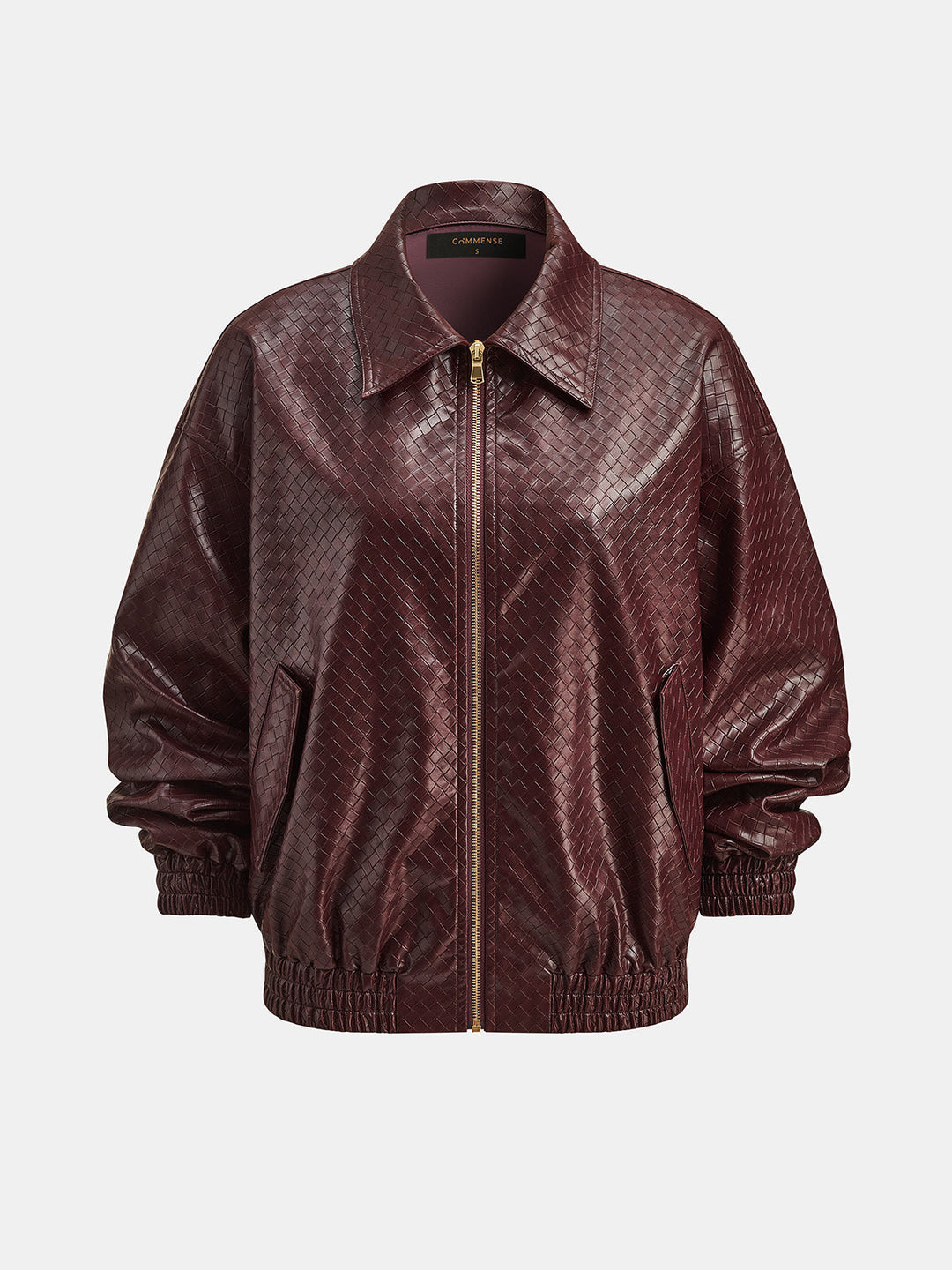 Angled view of the oversized burgundy bomber showing slant pockets and elastic hem