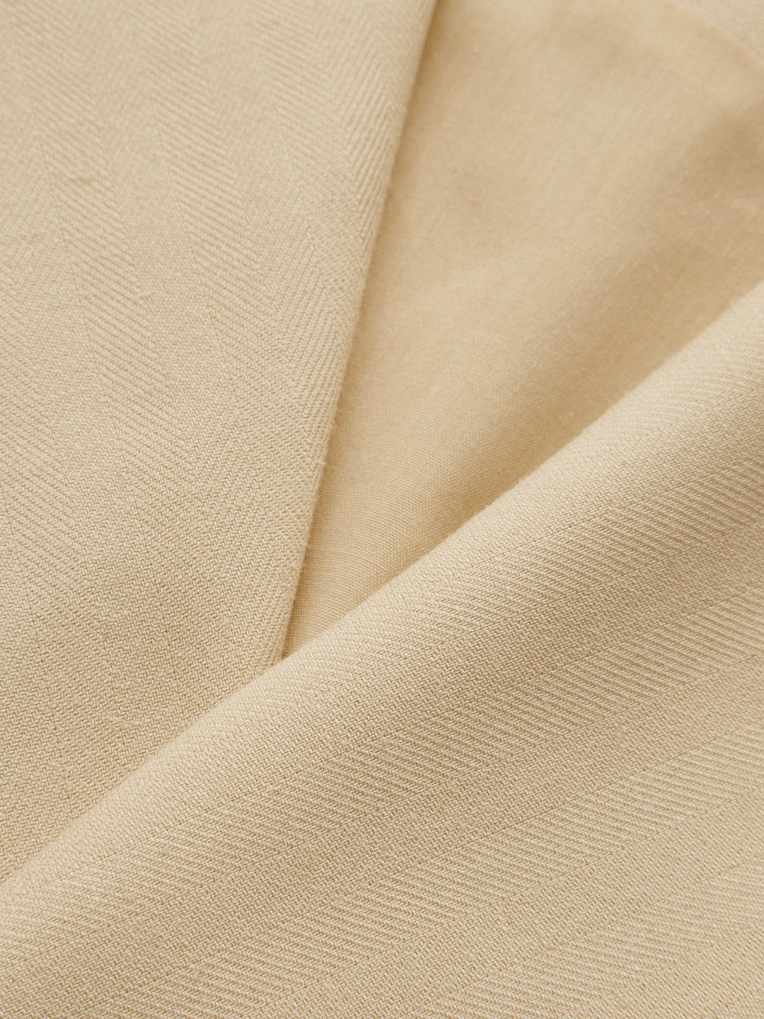 Draped close-up of the khaki fabric used for the ribbon tie shawl collar vest