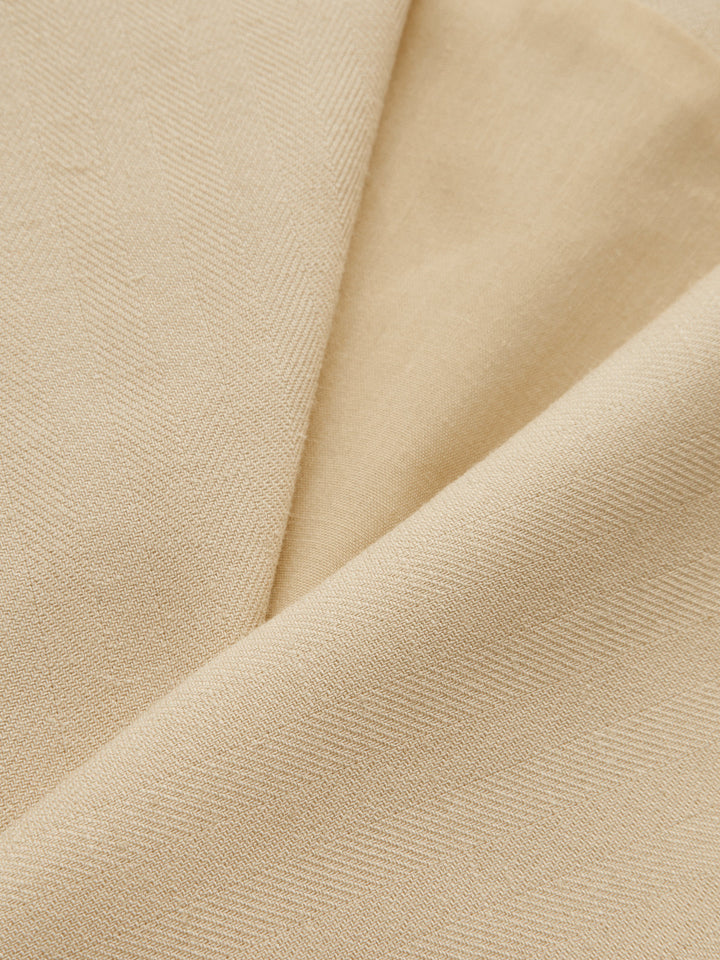 Draped close-up of the khaki fabric used for the ribbon tie shawl collar vest