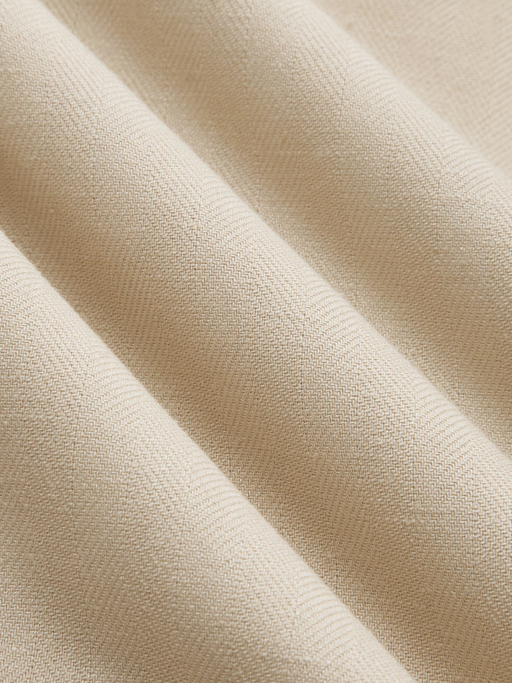 Macro of the smooth beige twill fabric of the shawl collar sleeveless vest