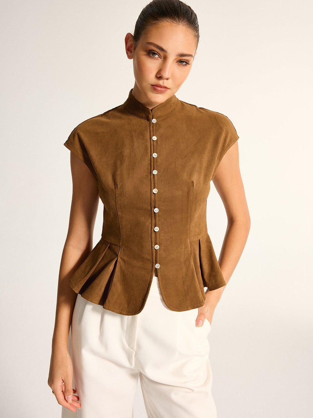 Front view of camel suede top with cap sleeves and pleated peplum hem