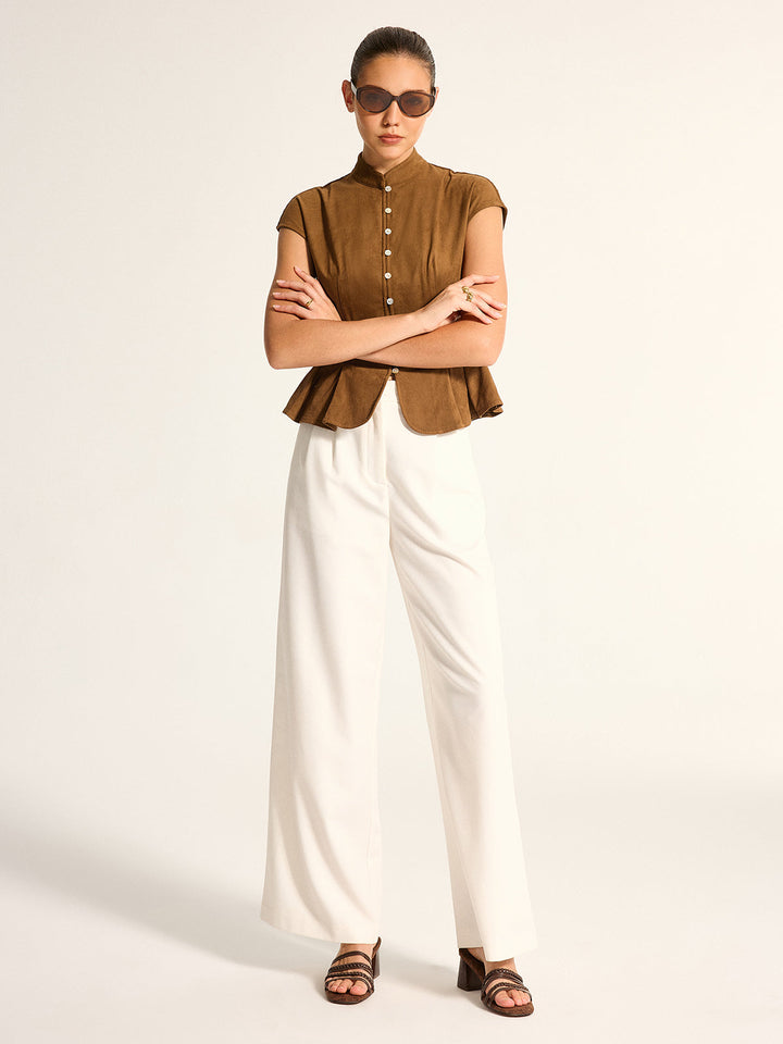Full-length tan suede peplum top styled with ivory trousers and flat sandals