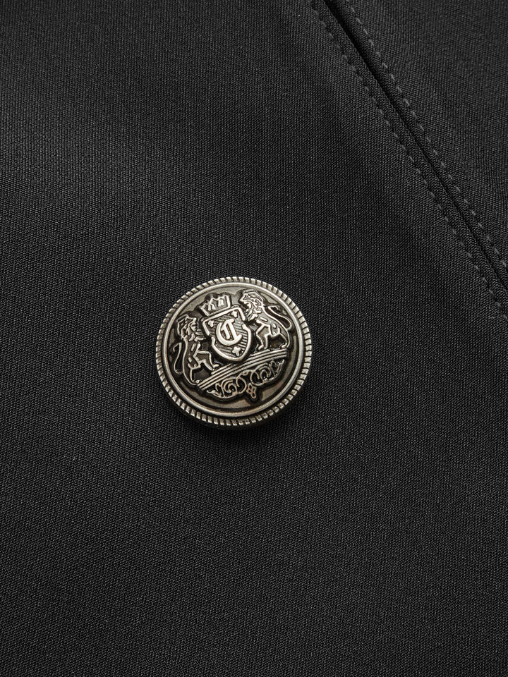Close-up of the antique silver crest button on black jacket fabric