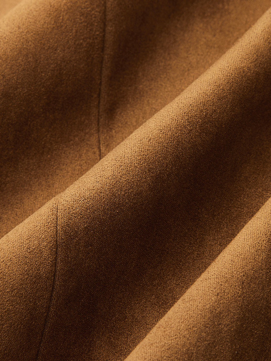 Macro shot of soft camel faux suede showing the brushed nap and warm caramel tone