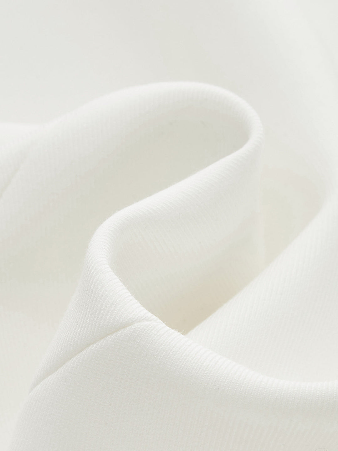 Macro of crisp off-white crepe fabric used for the cap sleeve peplum blouse
