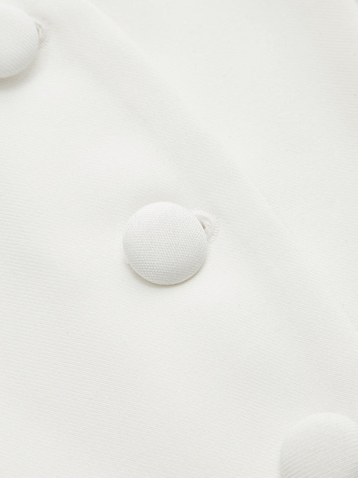 Close-up of self-covered white fabric buttons on the peplum blouse placket
