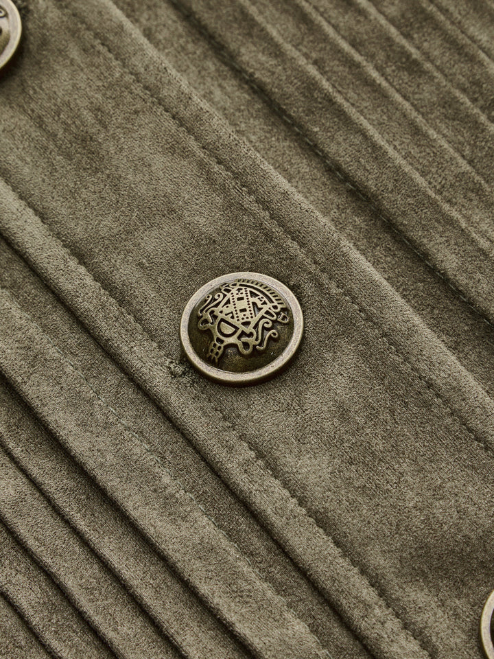 Detail of the ornate antique gold crest button and vertical pintucks on the green jacket