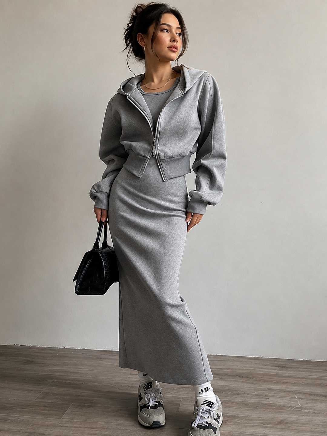 Woman in grey cropped zip hoodie with matching knit maxi skirt and trainers