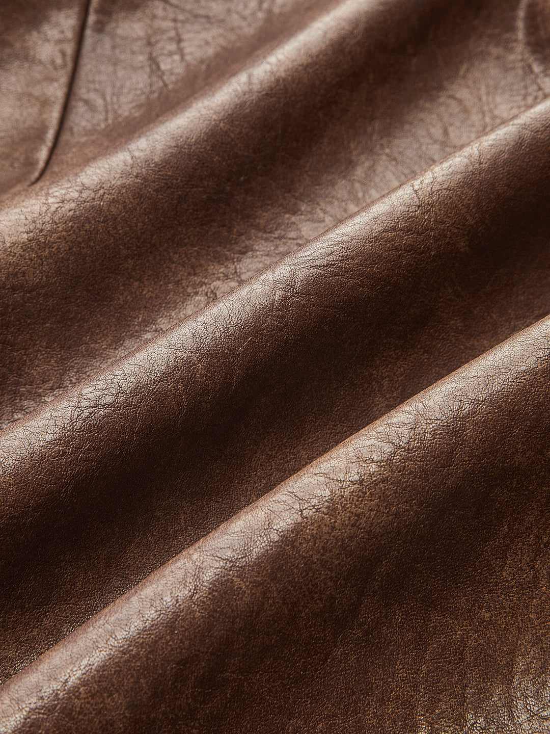 Fabric detail of soft brown faux leather with subtle vintage sheen