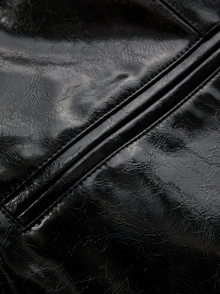 Detail of the welt pocket and crinkled high shine black leather look fabric