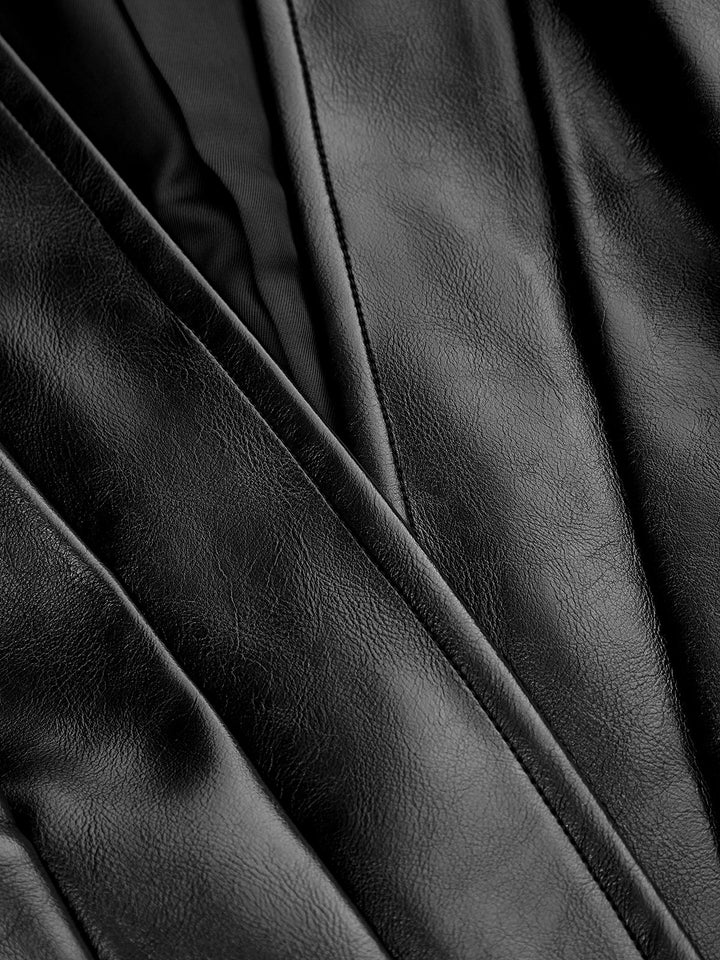 Close-up of smooth black faux leather showing panelled stitching