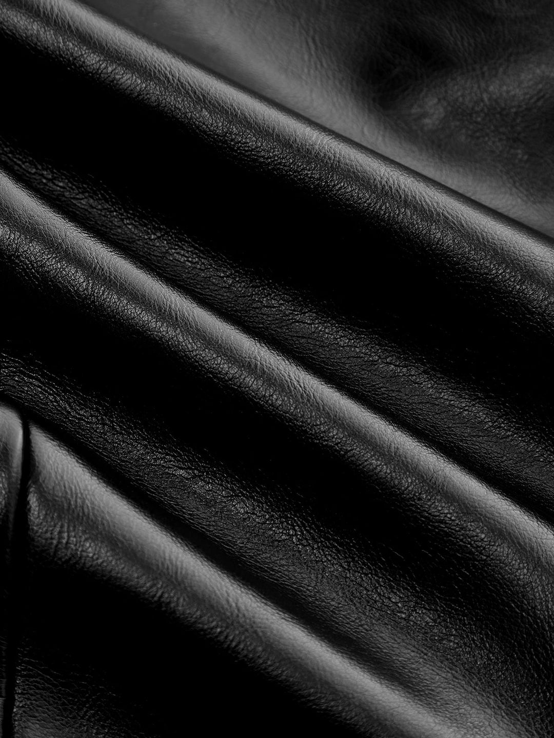 Detail of soft draped black faux leather fabric