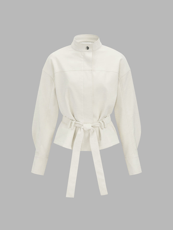 Front product view of ivory leather look jacket with stand collar and tie belt
