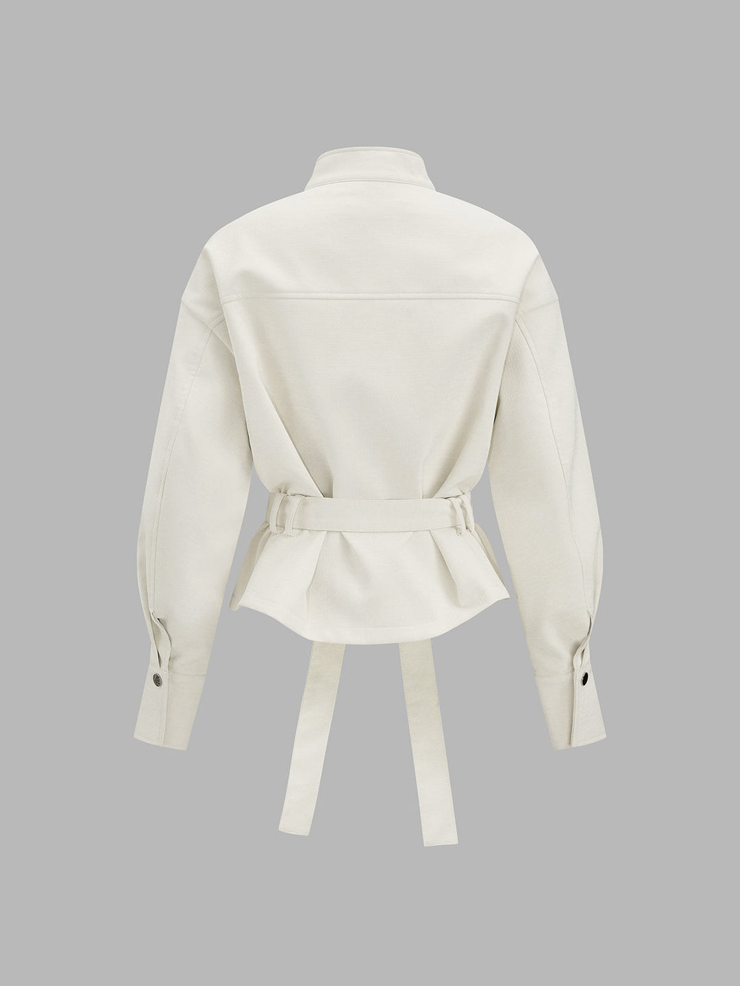 Back view of the cream belted jacket showing peplum hem and buttoned cuffs