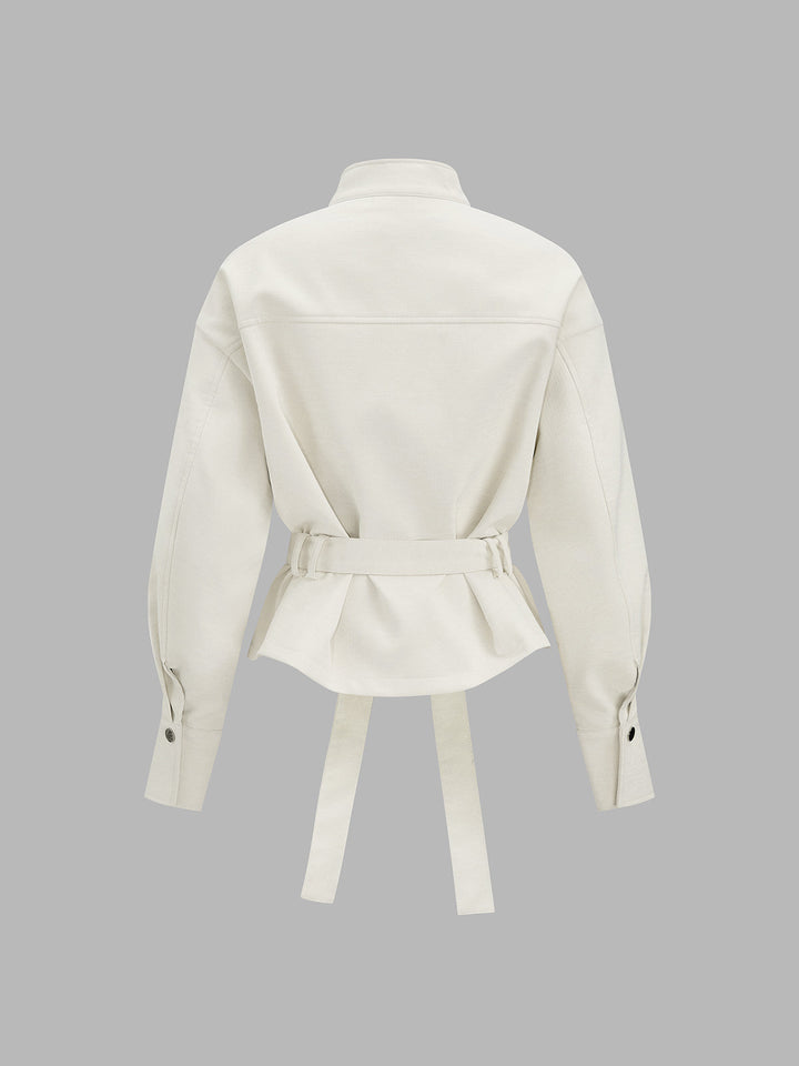 Back view of the cream belted jacket showing peplum hem and buttoned cuffs