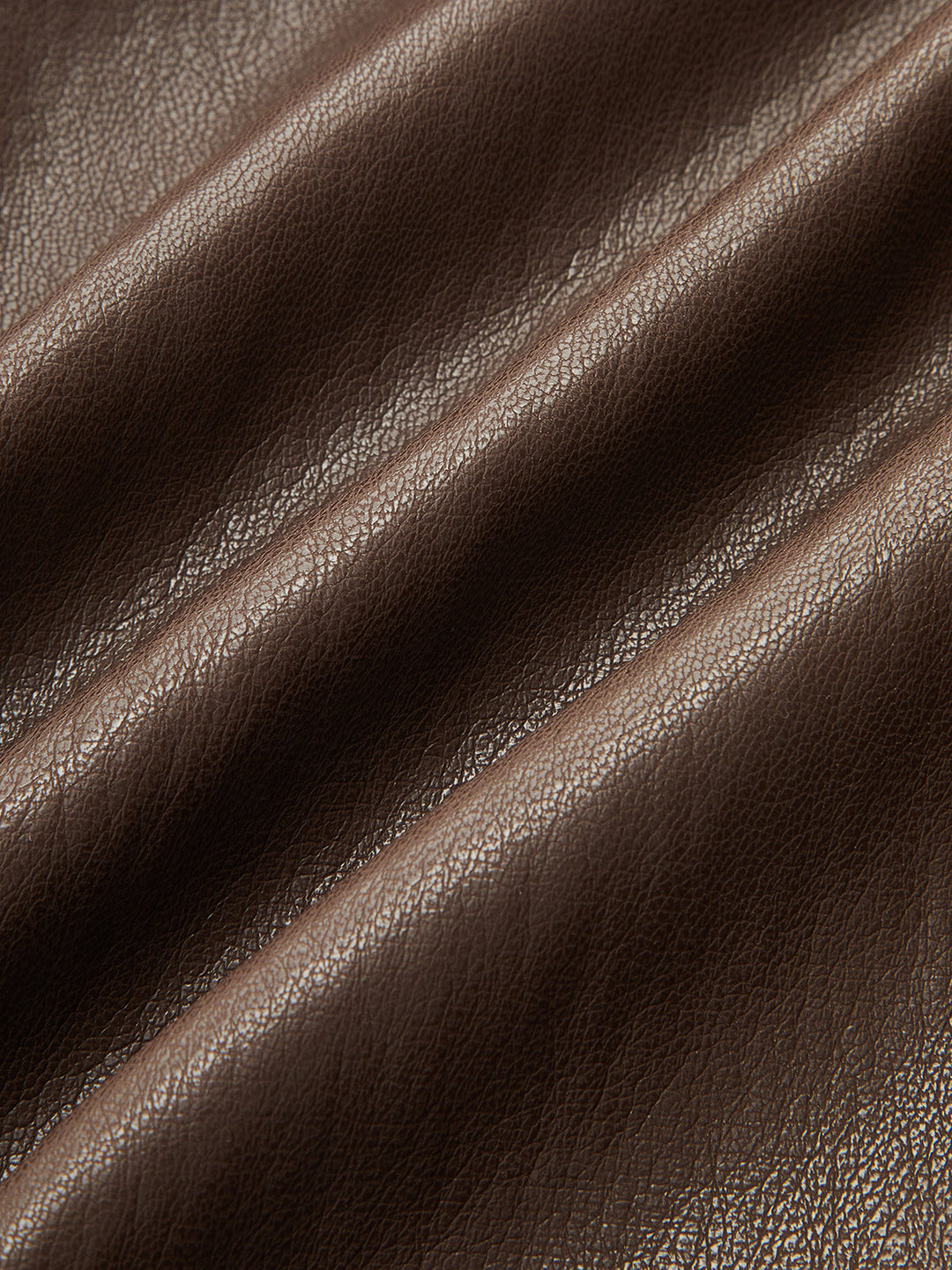 Texture close-up of the soft grained chocolate brown faux leather