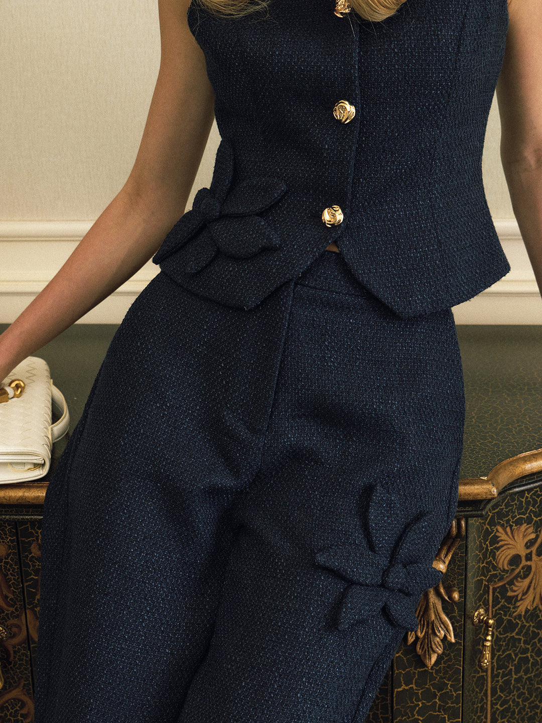 Detail of navy fabric flower applique and gold metal buttons on the tweed vest