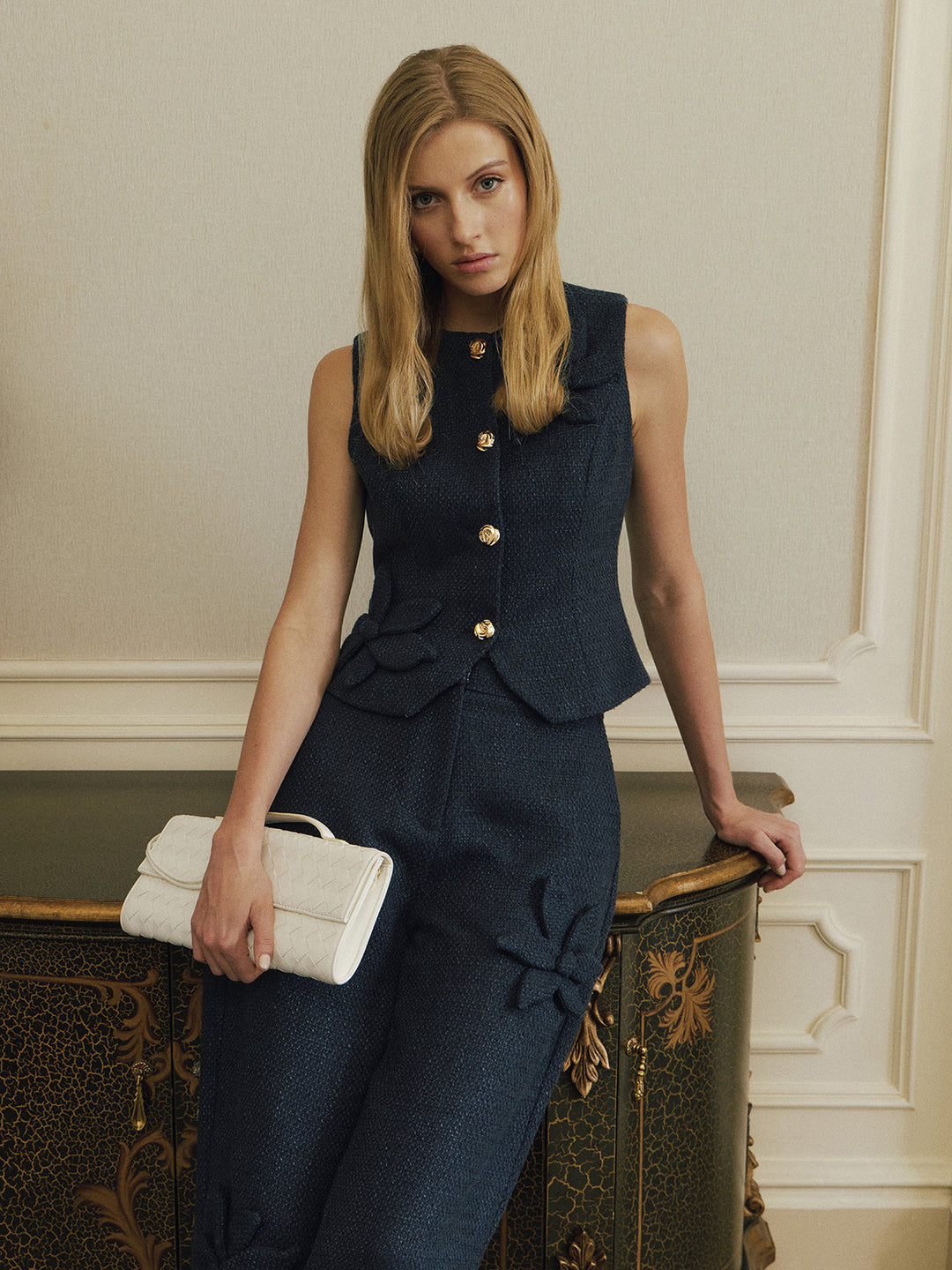 Front view of dark blue tweed waistcoat with round neck and peplum hem
