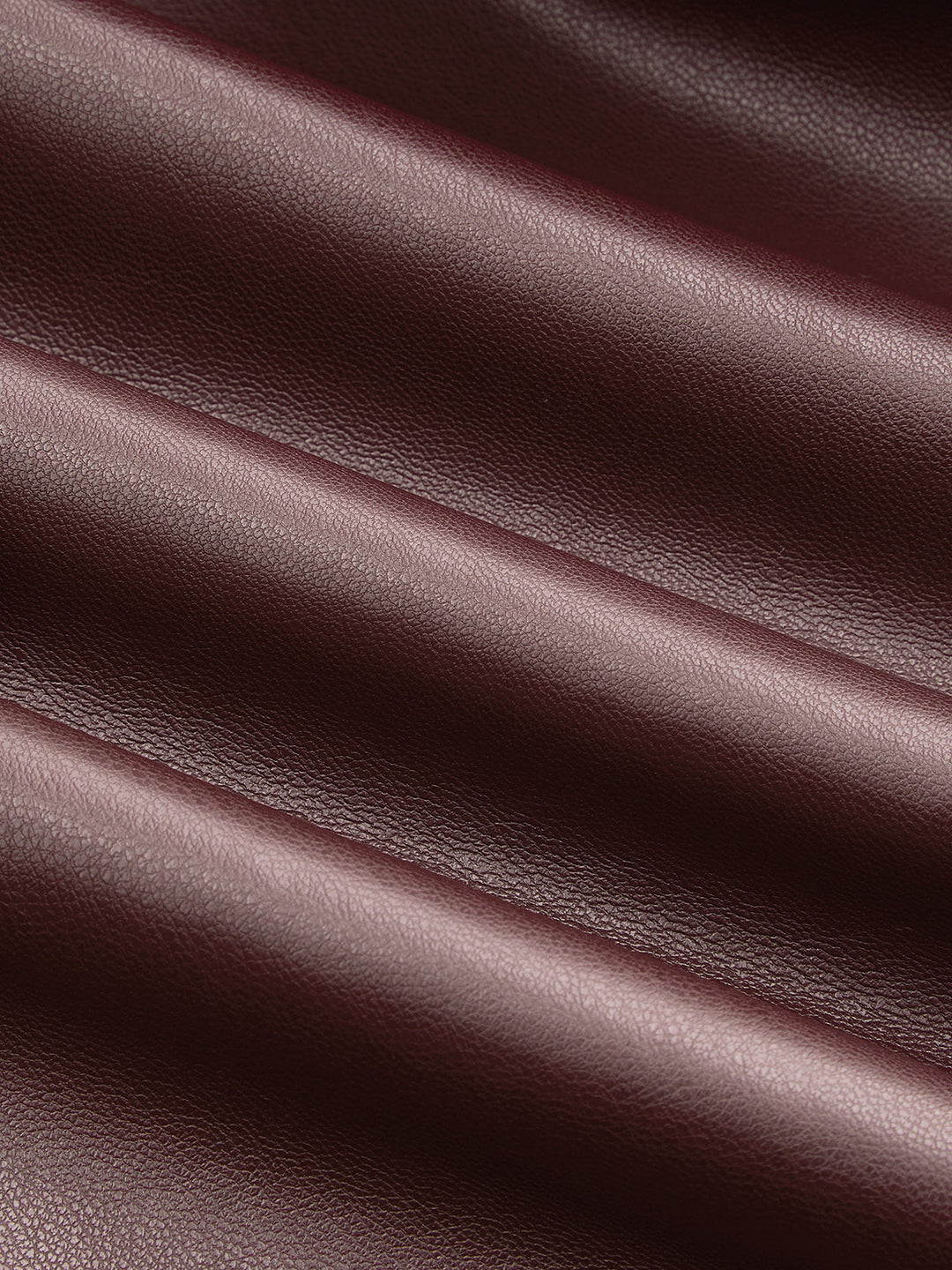 Texture detail of the smooth deep burgundy faux leather