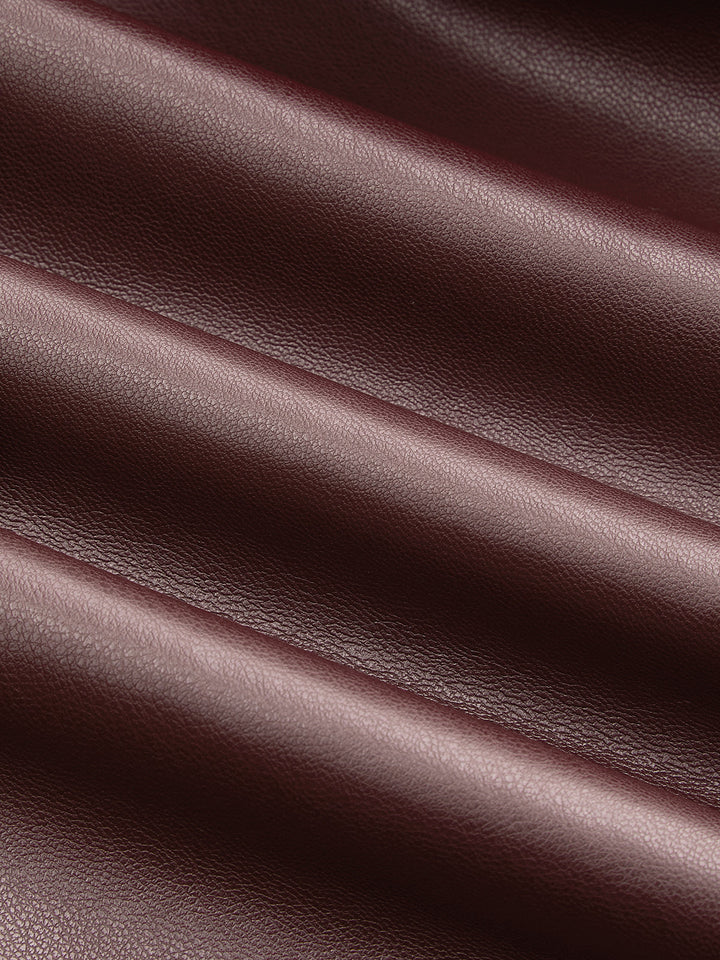 Texture detail of the smooth deep burgundy faux leather