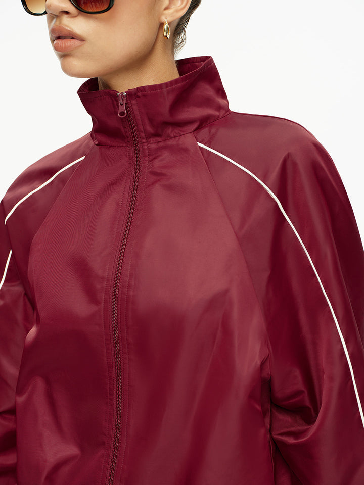 Close-up of the zipped stand collar and white piping on the burgundy jacket