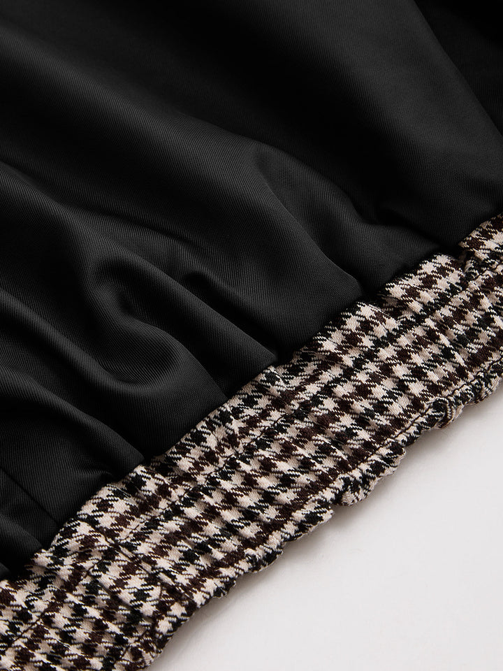 Detail of black satin lining beside the brown houndstooth sleeve of a cropped jacket