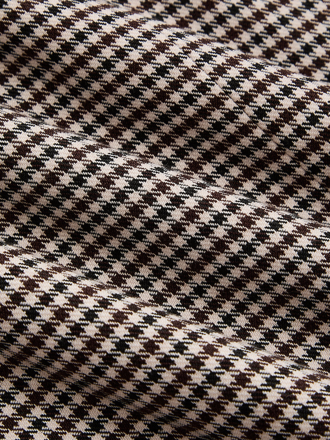 Macro of the brown, black and cream houndstooth check woven fabric