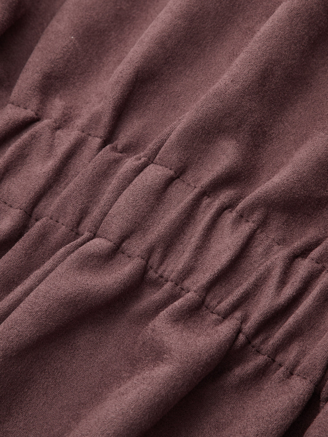 Detail of the gathered waist shirring on soft plum coloured faux suede