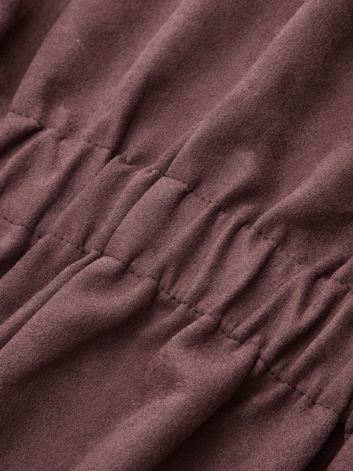 Detail of the gathered waist shirring on soft plum coloured faux suede
