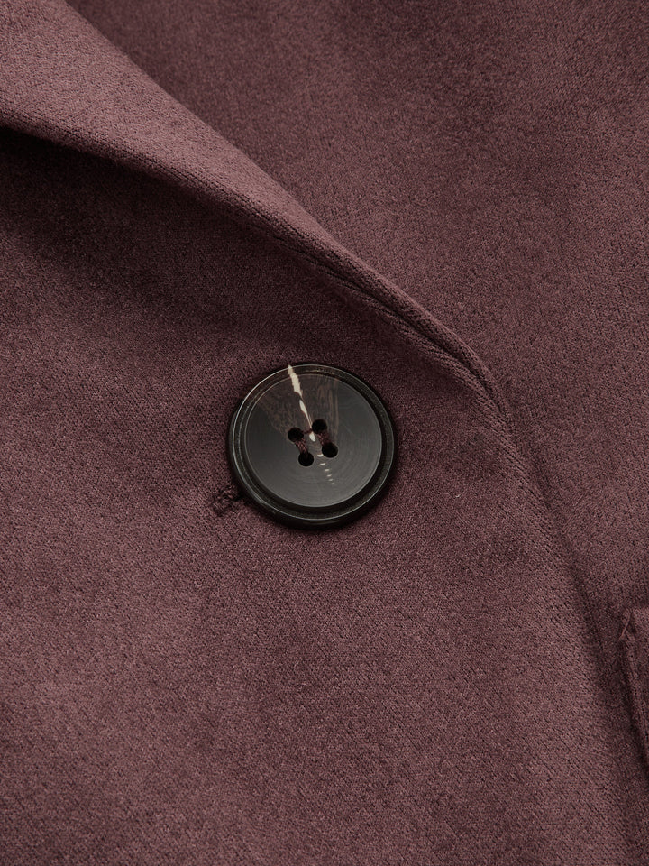 Close-up of the dark horn button and shawl collar on the burgundy faux suede jacket