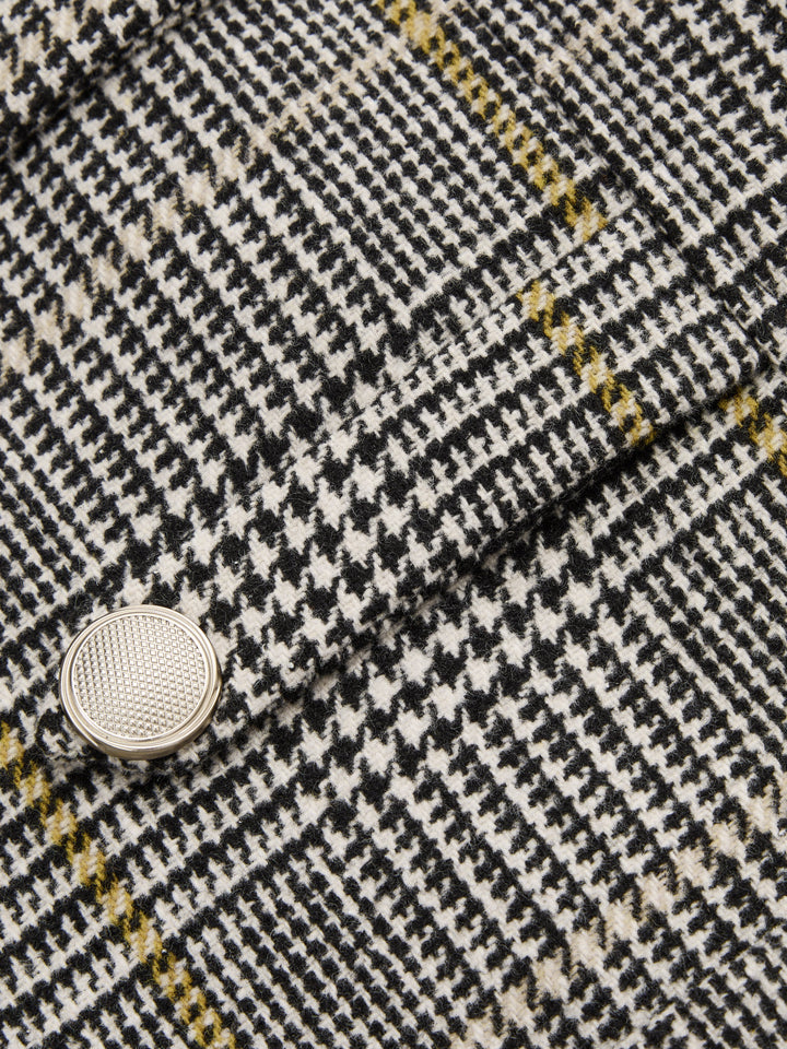 Close-up of silver dome button on grey houndstooth check tweed jacket