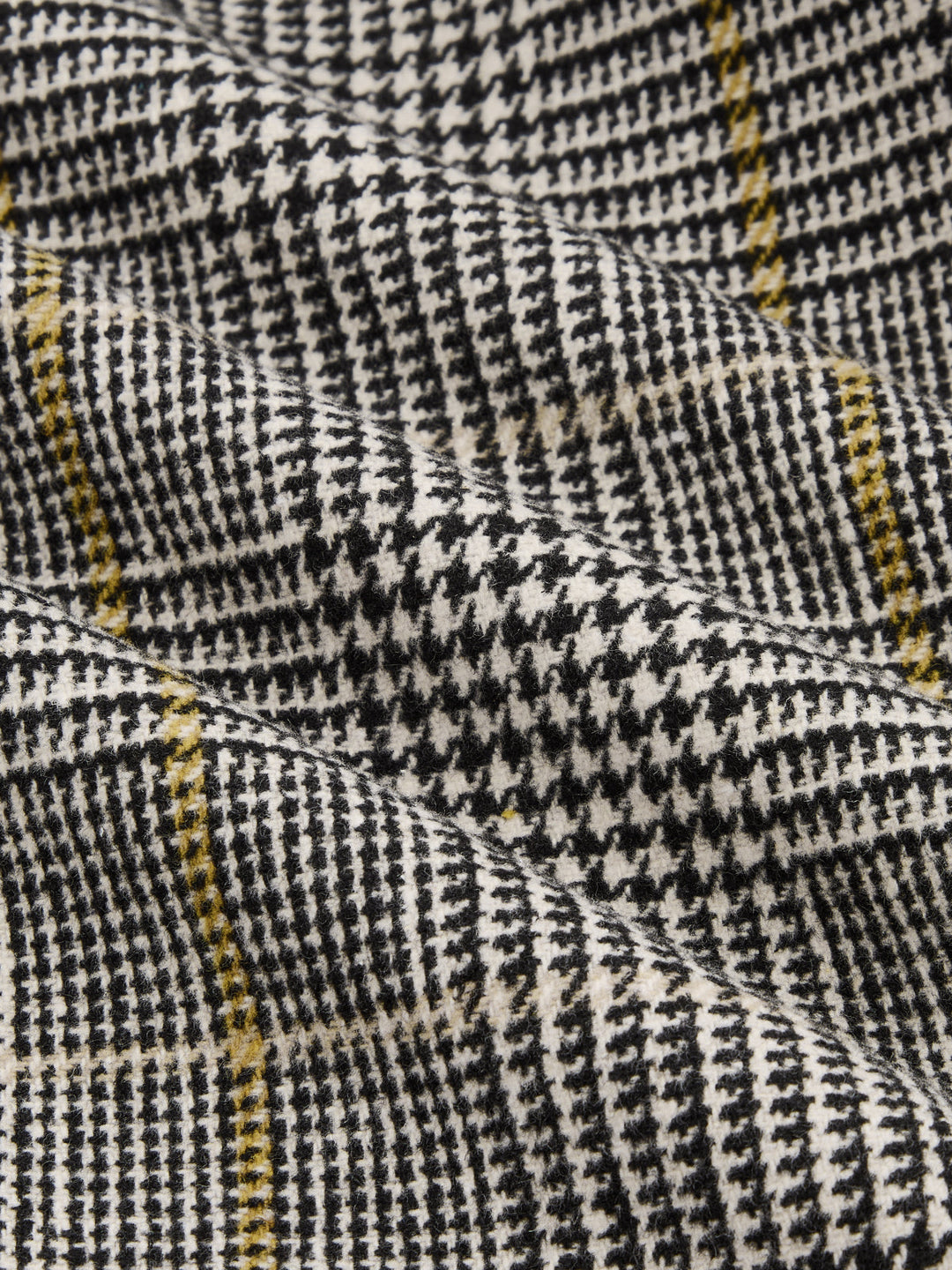 Fabric detail of black, white and yellow houndstooth check weave