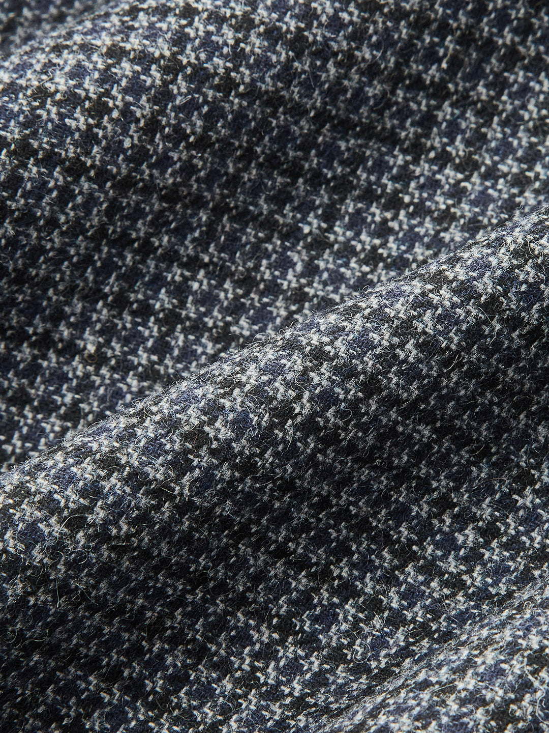 Fabric detail of the grey and navy houndstooth wool blend