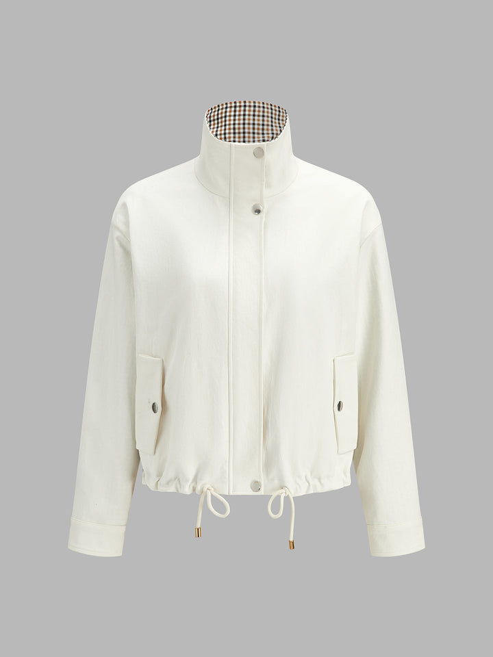 Product shot of off-white reversible jacket showing check-lined stand collar and zip front