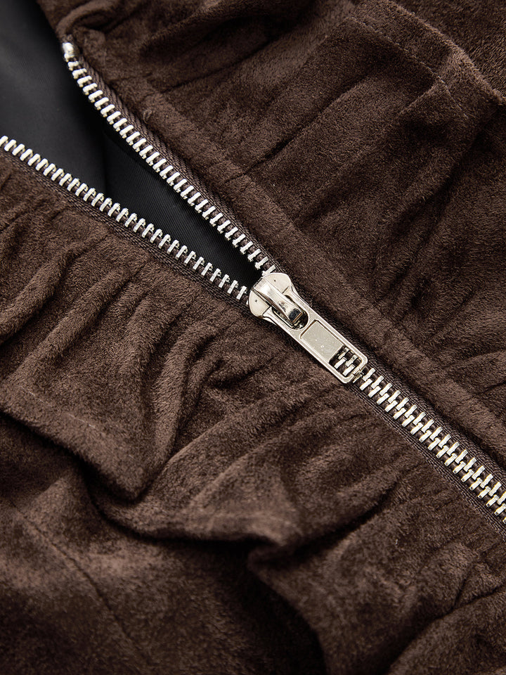 Close-up of the silver zipper pull on the ruched brown suede jacket front