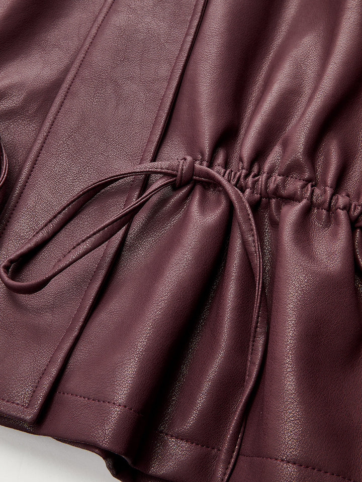 Detail of the drawstring cord and elasticated waist on burgundy faux leather