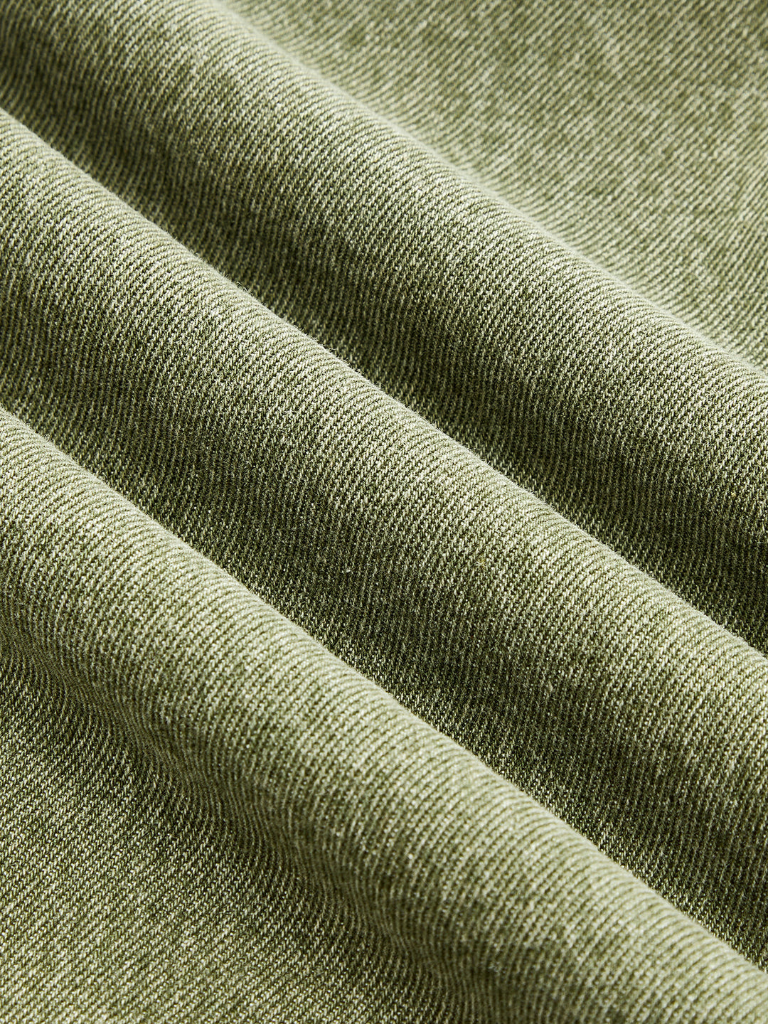 Texture detail of the faded olive green denim twill