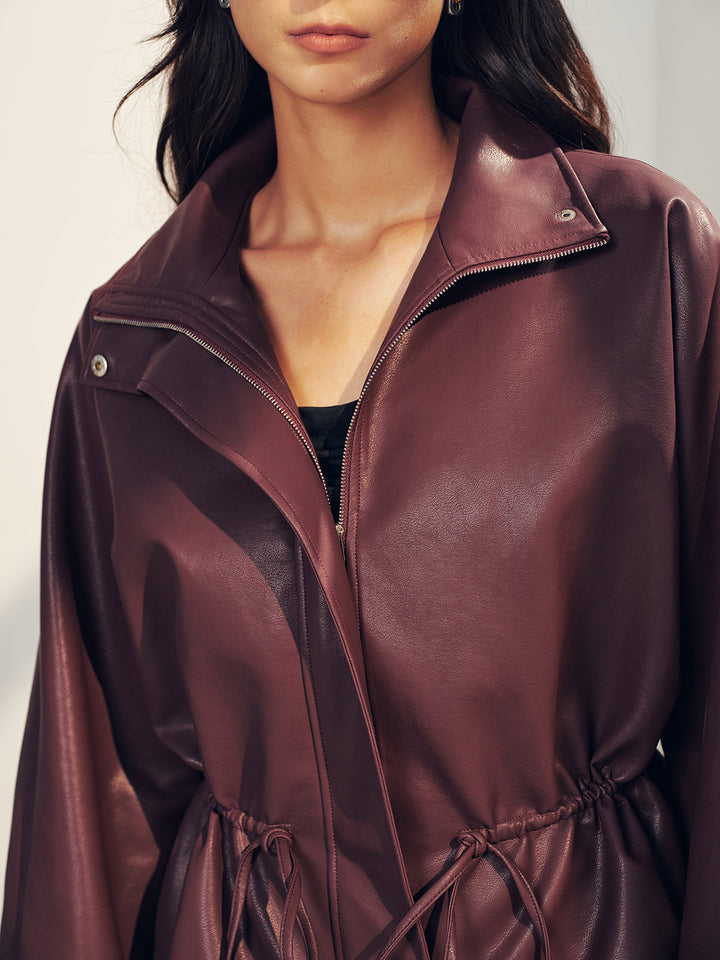 Close styling shot of the open funnel collar and zip of the wine faux leather jacket