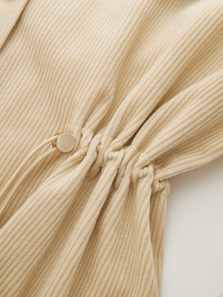 Detail of the drawstring waist toggle gathering the corduroy fabric