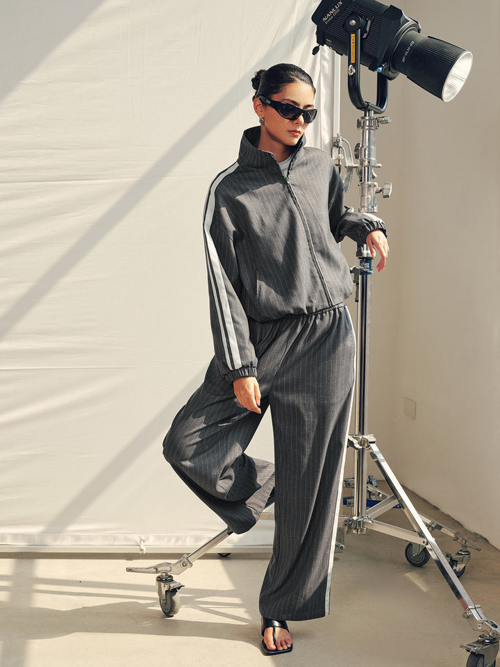 Full length view of the grey pinstripe tracksuit set on a studio backdrop