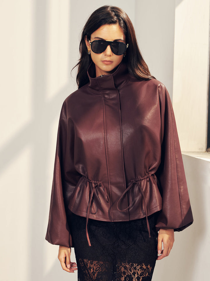Model outdoors in burgundy drawstring waist jacket over black lace skirt