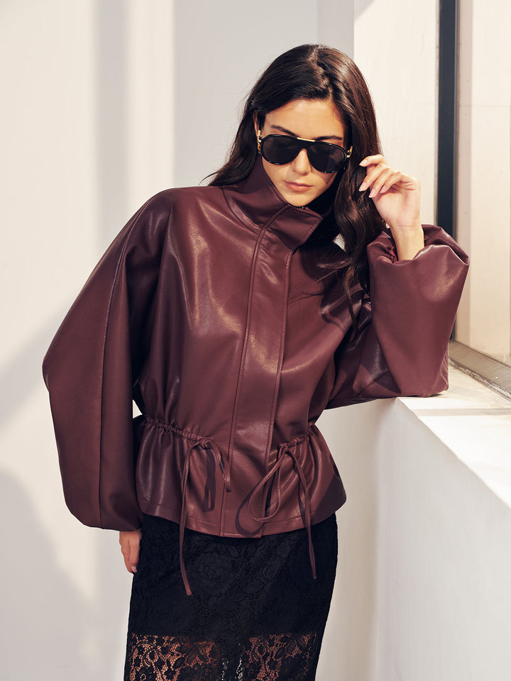Close portrait of the high funnel collar on the burgundy faux leather jacket