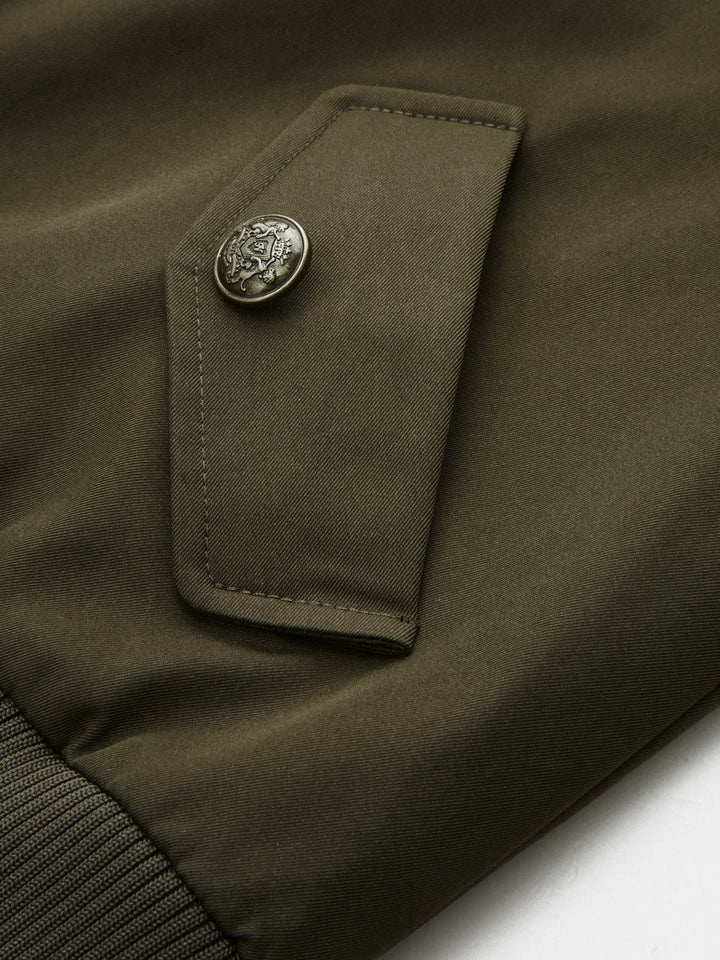 Close-up of engraved metal button on the flap pocket of the green bomber jacket