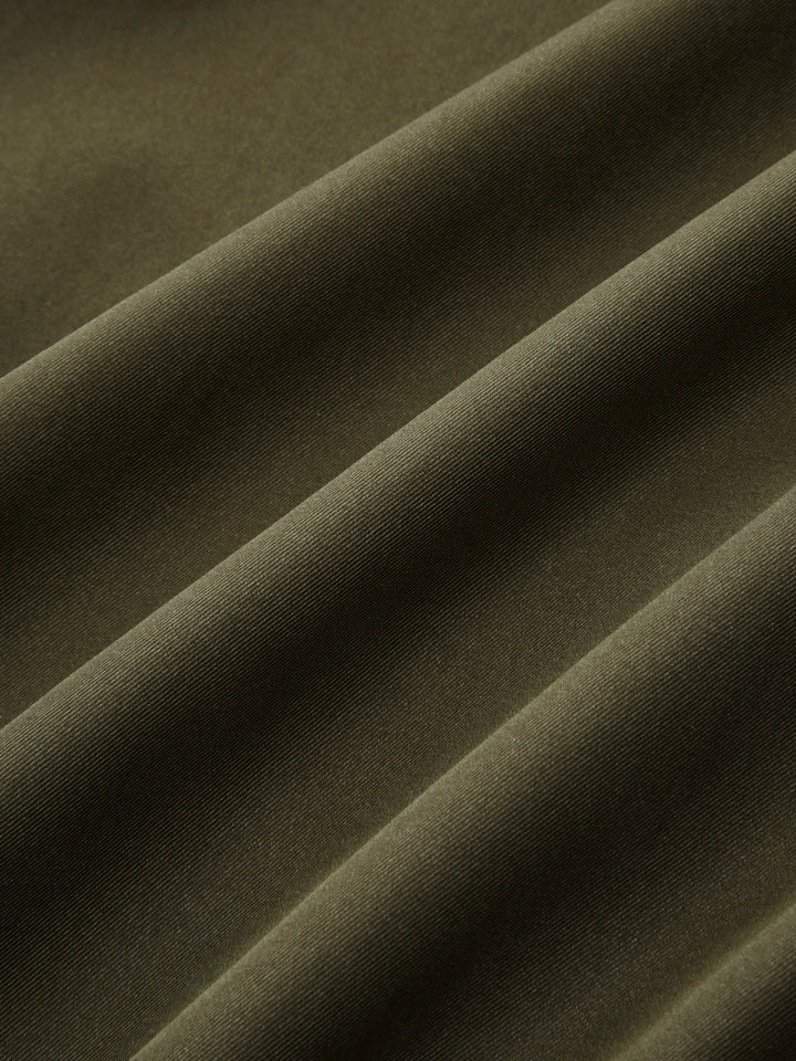 Fabric close-up showing the soft matte army green twill of the bomber jacket