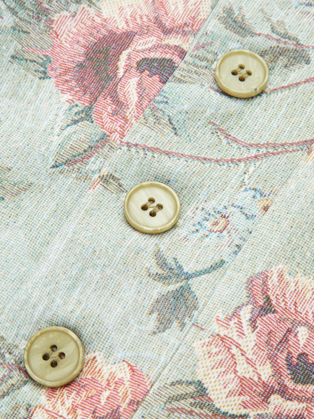 Close-up of cream four-hole buttons on the rose tapestry front of a stand collar jacket